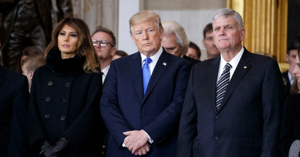 President Donald Trump and first lady Melania Trump stand with Franklin Graham during a ceremony as the late evangelist Billy Graham lies in repose at the U.S. Capitol.