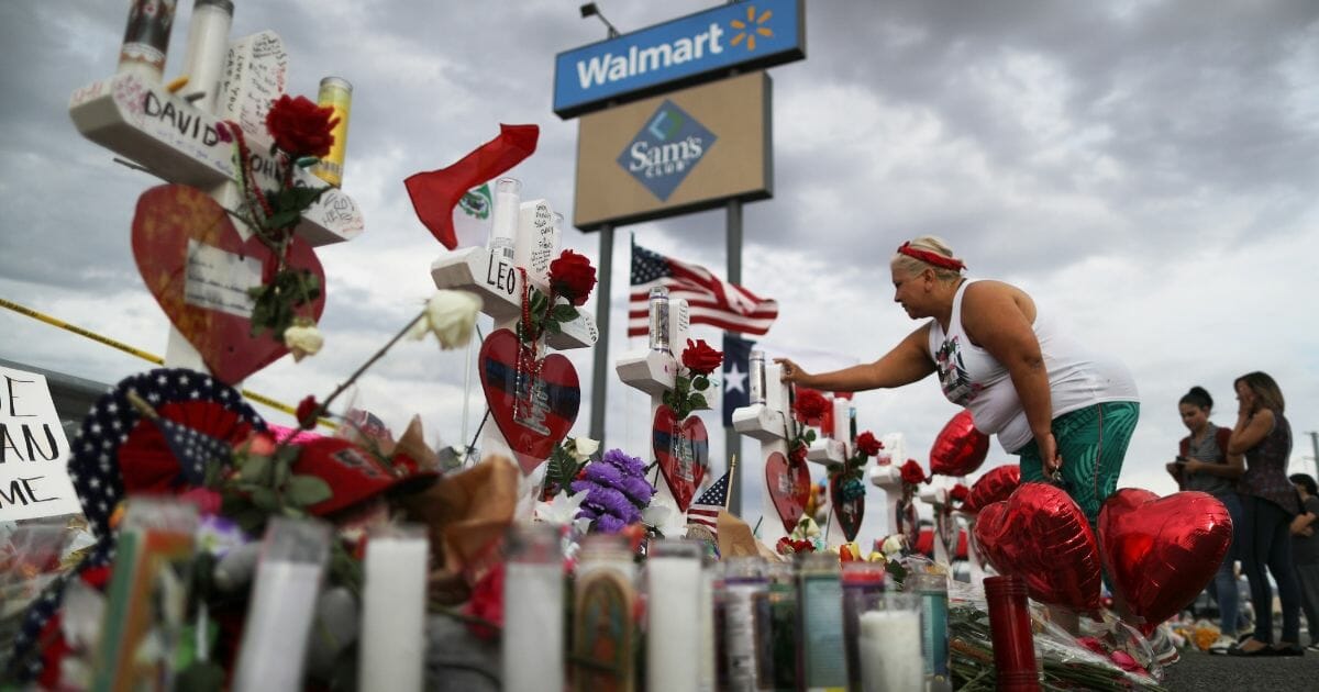 A woman touches a cross at a makeshift memorial for victims outside Walmart, near the scene of a mass shooting which left at least 22 people dead, on August 6, 2019 in El Paso, Texas.
