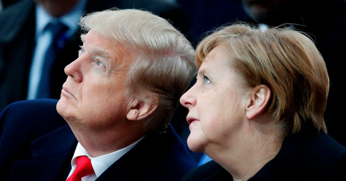 U.S. President Donald Trump, left, and German Chancellor Angela Merkel, right, attend a ceremony at the Arc de Triomphe in Paris on November 11, 2018 as part of commemorations marking the 100th anniversary of the 11 November 1918 armistice, ending World War I.
