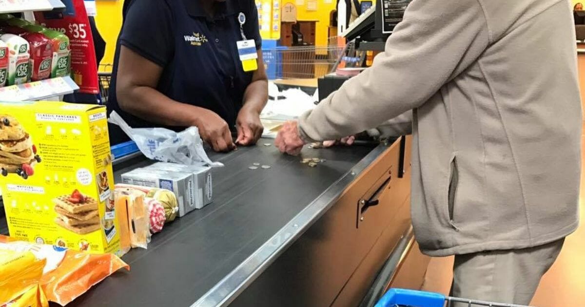 Cashier helps elderly man count coins.