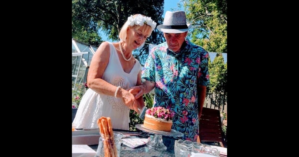 Elderly couple cuts cake.