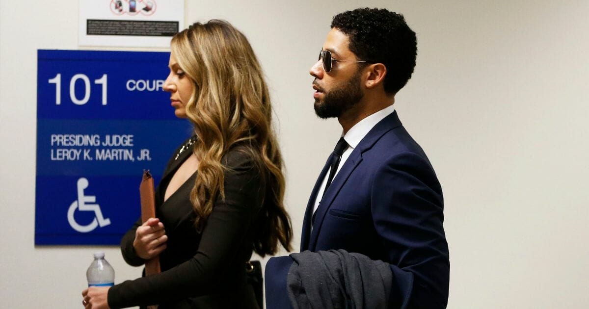 Actor Jussie Smollett (R) and attorney Tina Glandian walk in Leighton Criminal Courthouse for his court appearance on March 14, 2019 in Chicago, Illinois.