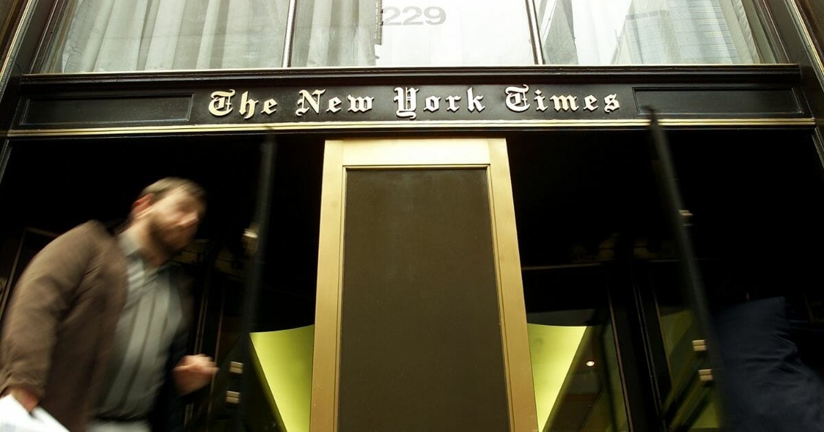 A pedestrian walks past the entrance to The New York Times building