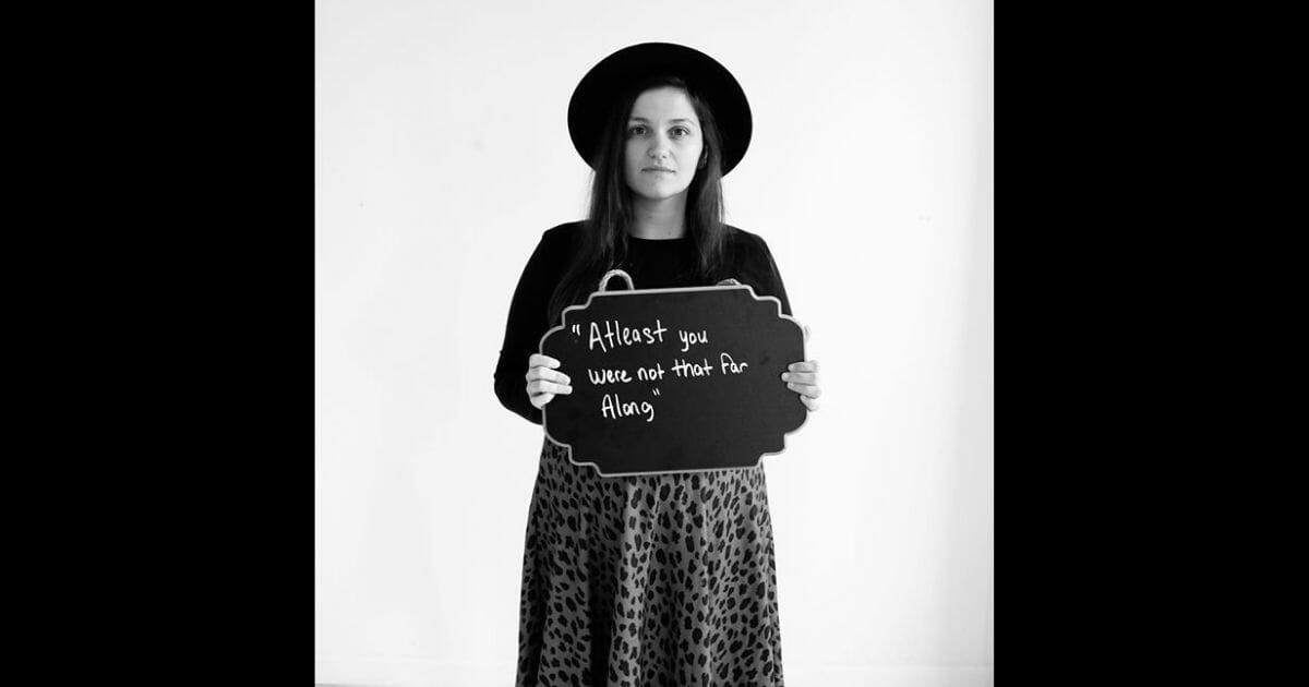 A mother who experienced a miscarriage poses with a hurtful message she received.