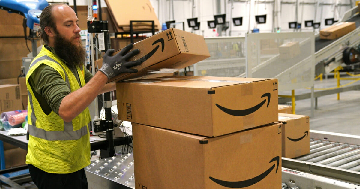 A worker moves packed boxes at the Amazon fullfillment center in Aurora, Colorado, on May 3, 2018.