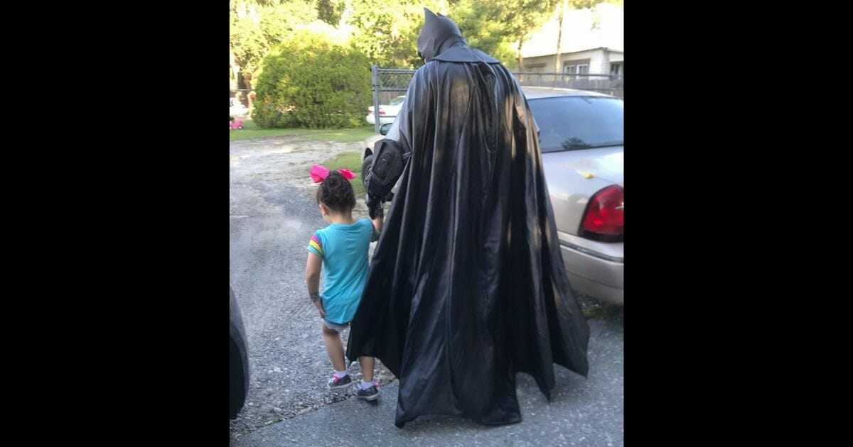 Batman impersonator escorts girl to school.