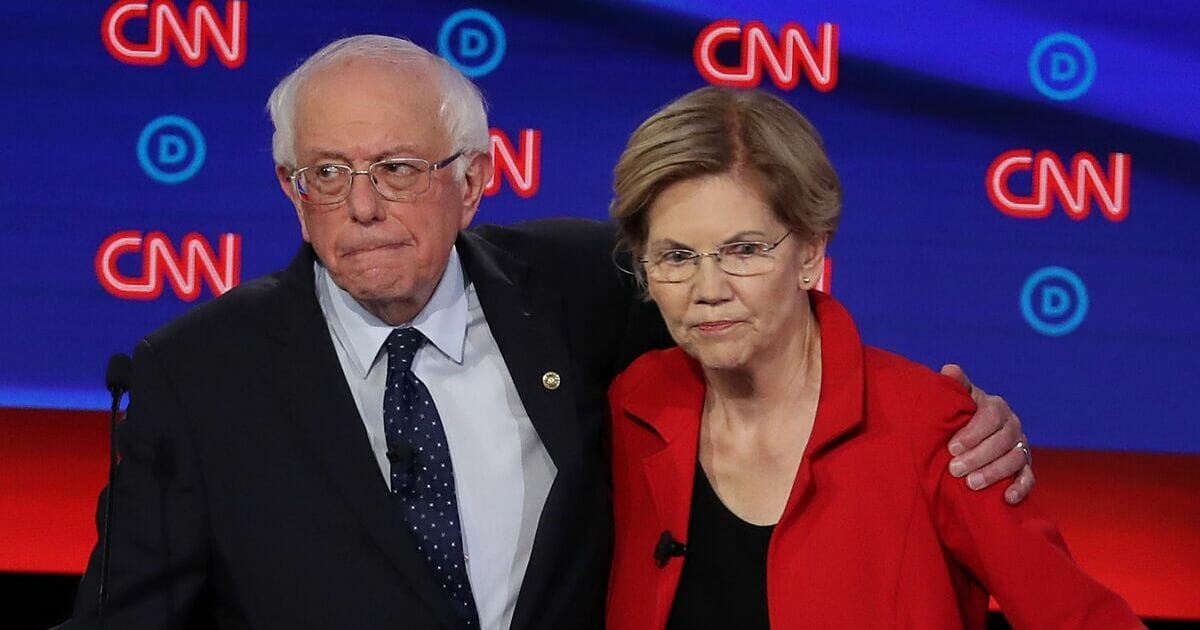 Democratic presidential candidates Sens. Bernie Sanders of Vermont and Elizabeth Warren of Massachusetts embrace after the Democratic Presidential Debate at the Fox Theatre July 30, 2019, in Detroit, Michigan.