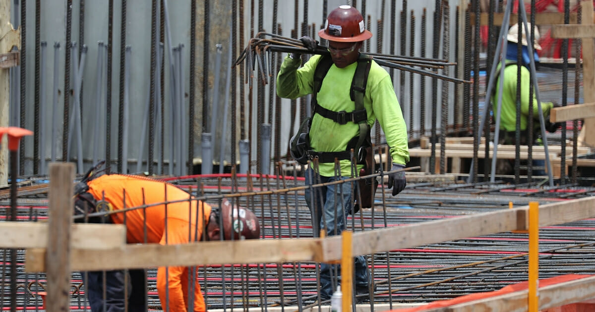 Construction workers are seen on the job May 3, 2019, in Fort Lauderdale, Florida.