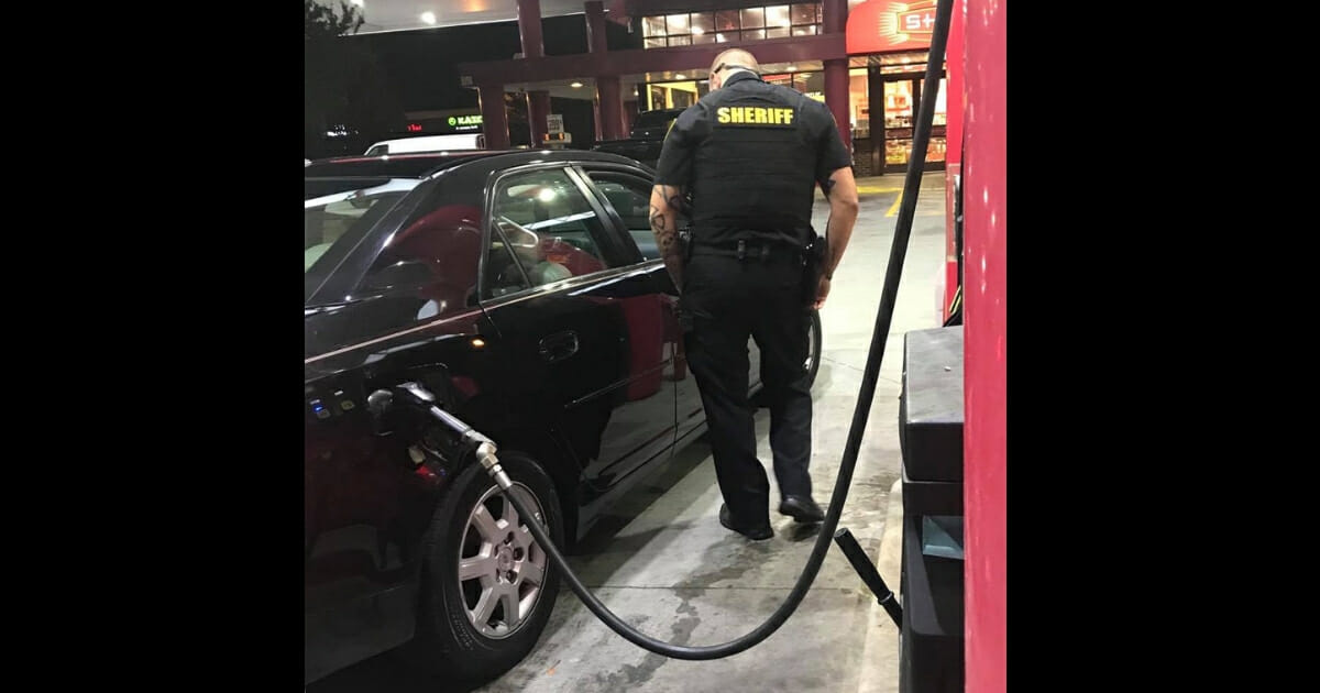 Deputy Sheriff Chris Owen of the Forsyth County Sheriff's Office fills up a woman's car with gas so she can get home safely.