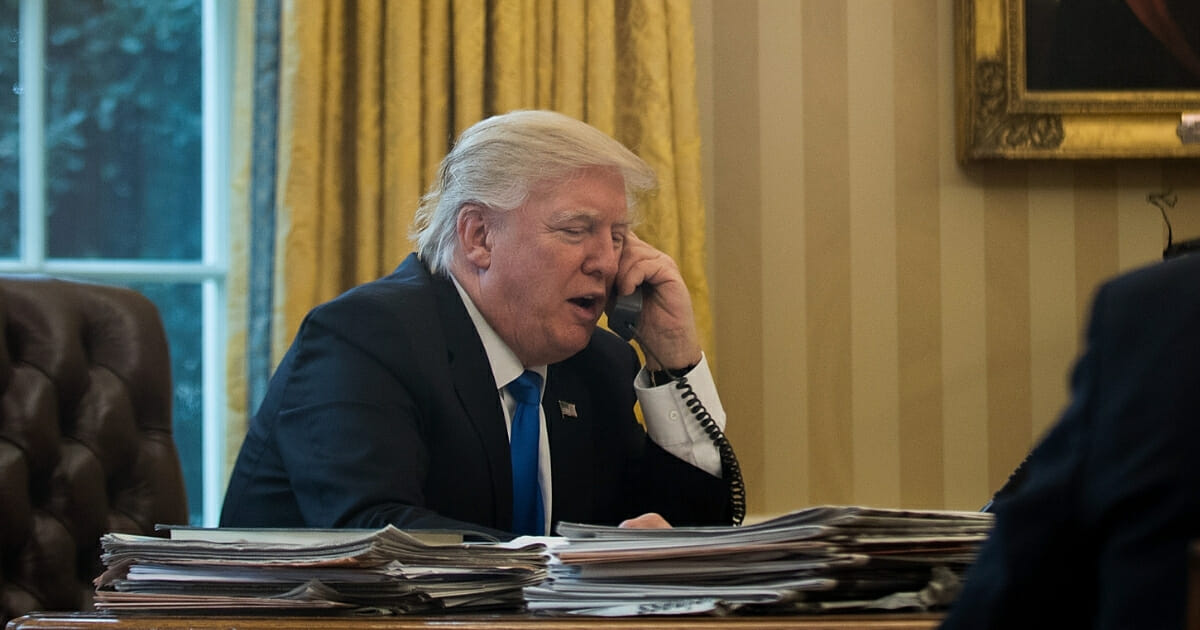President Donald Trump speaks on the phone with Chancellor of Germany Angela Merkel in the Oval Office of the White House on Jan. 28, 2017, in Washington, D.C.