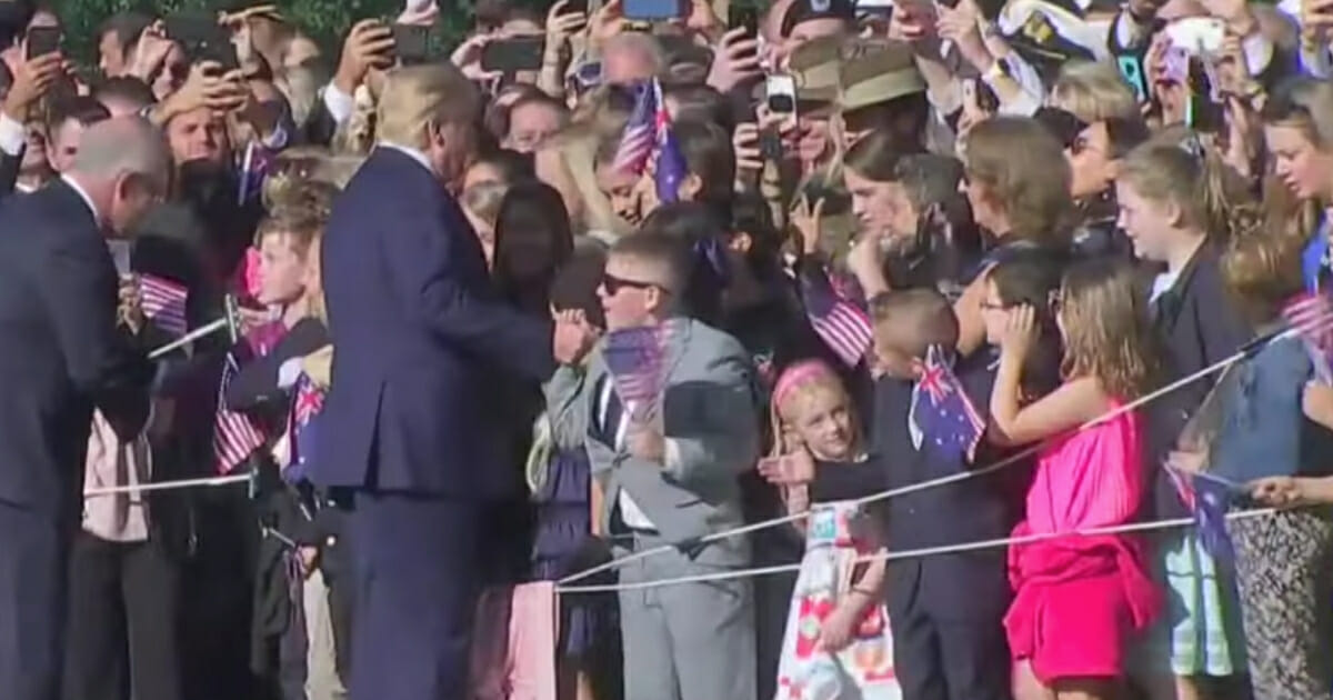 With the crowd looking on, the boy reached out both hands and embraced President Donald Trump in a full-on bear hug. The president patted him on the back, then moved on down the handshake line.