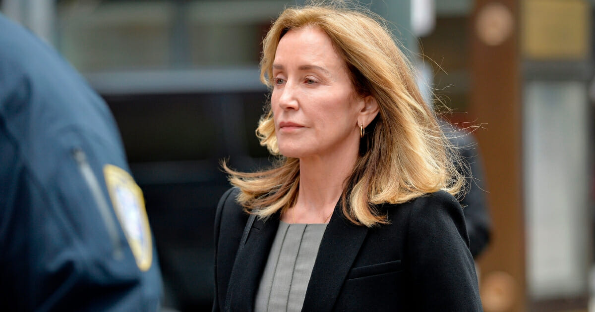 Actress Felicity Huffman is escorted by police into court in Boston.