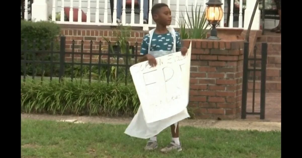 Little boy holds a sign