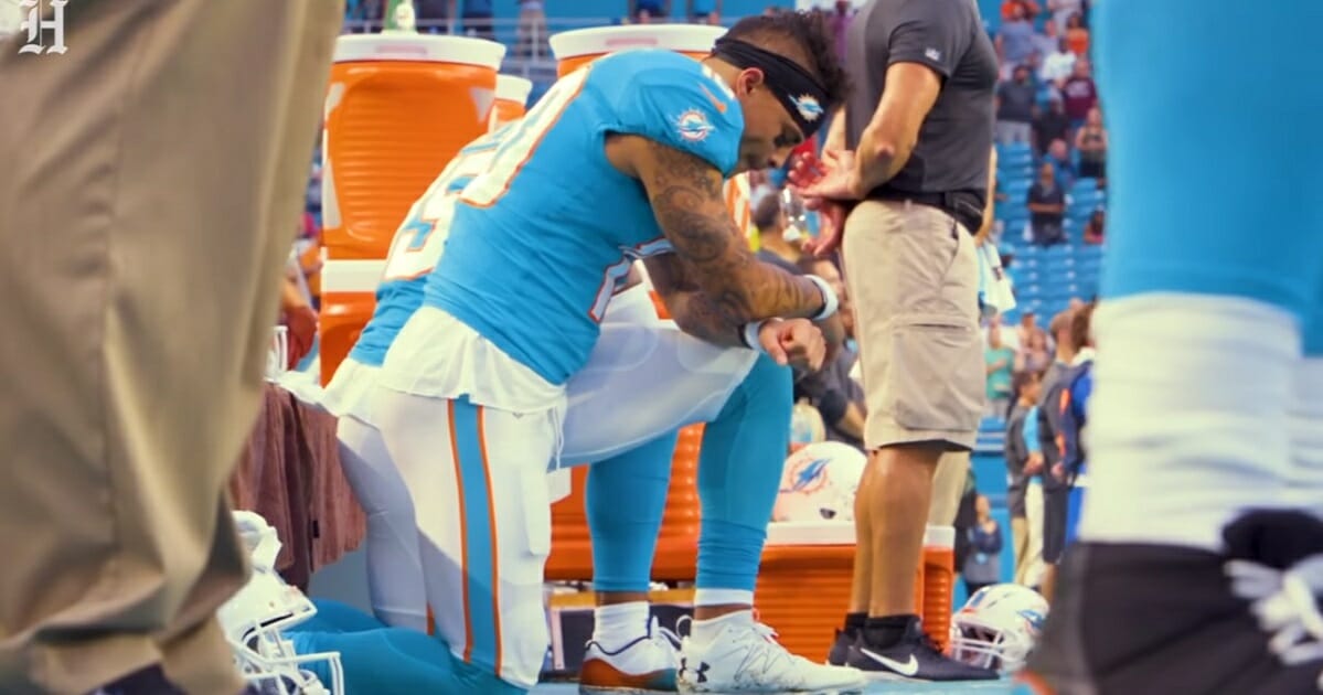 Miami Dolphins receiver Kenneth Stills kneels for "The Star-Spangled Banner" before a pres-season game in 2018.