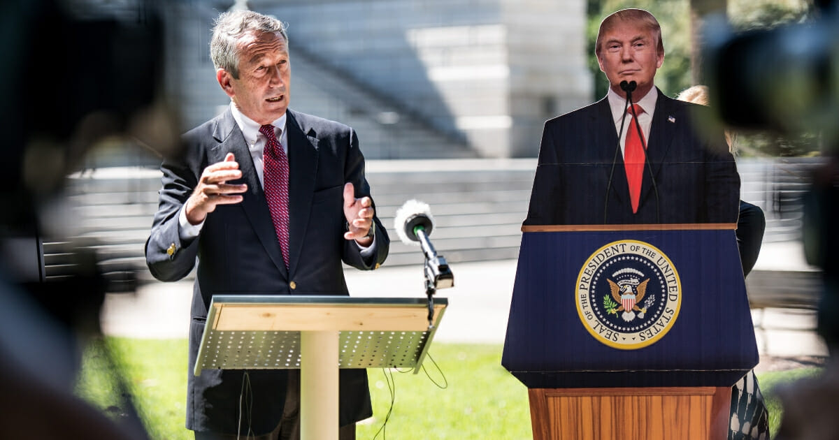 Former South Carolina Gov. Mark Sanford speaks to the media with a cardboard cutout of President Donald Trump during a campaign stop at the state house on Sept. 16, 2019, in Columbia, South Carolina.