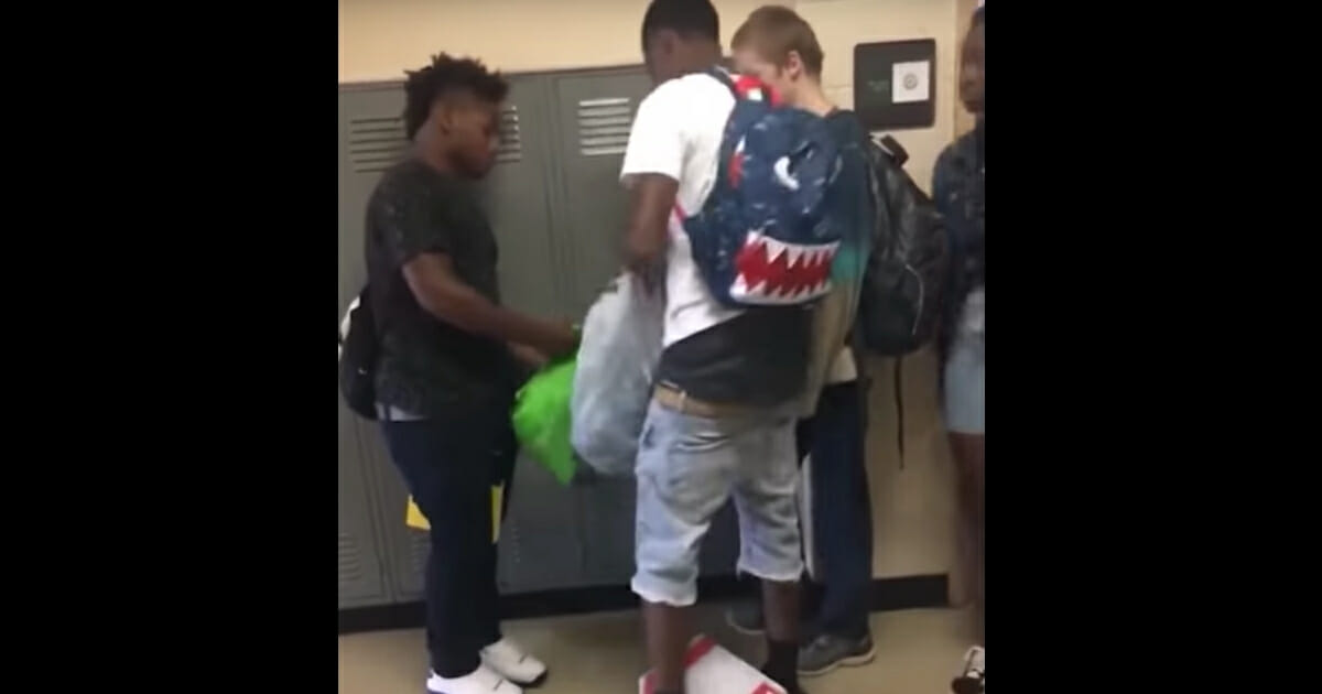 Two football players at Martin Luther King Jr. College Preparatory School in Memphis, Tennessee, give clothes to a classmate in need.