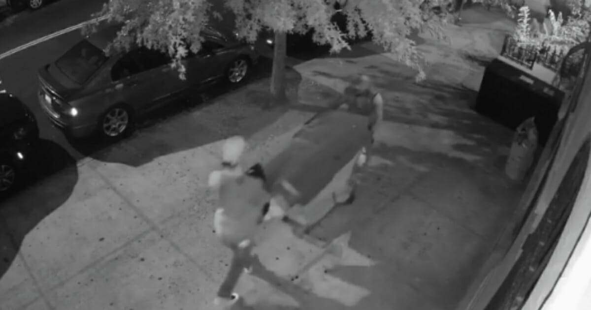 An incredibly strange video shows two men pushing a dead body rolled up in a carpet on top of a shopping cart through the streets of New York City -- along with a man riding his bicycle right past it.