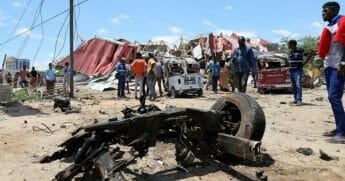 Somalis inspect the damage caused at the scene of an attack on an Italian military convoy in Mogadishu on Sept. 30, 2019.