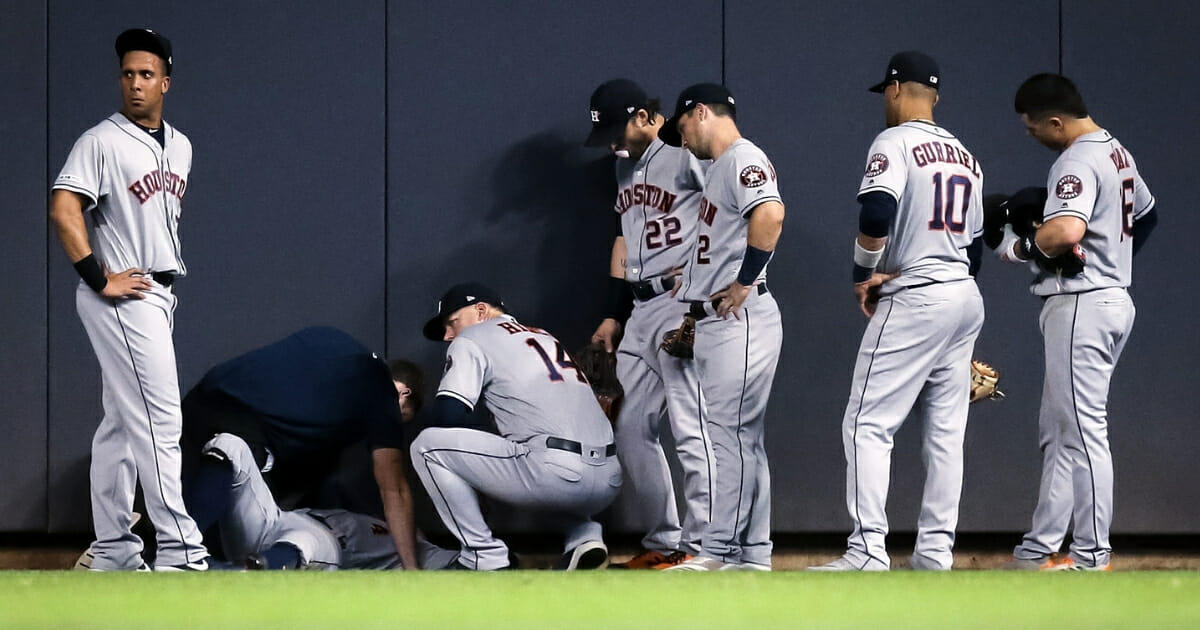 George Springer of the Houston Astros is attended to after hitting the wall in the fifth inning against the Milwaukee Brewers.