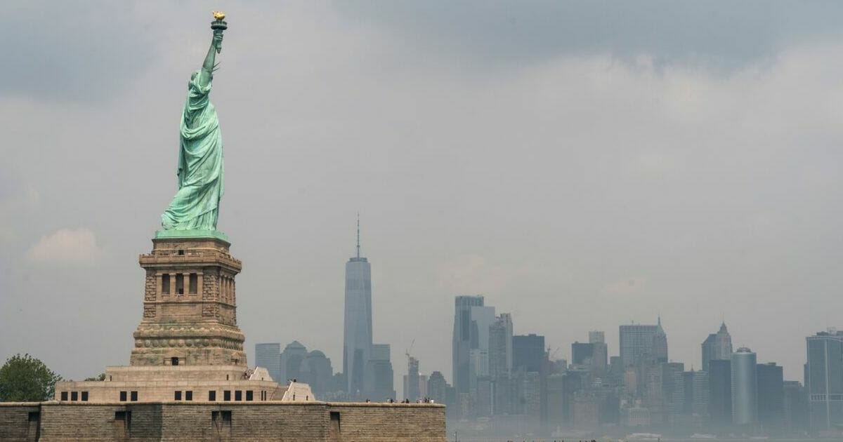 With the Lower Manhattan skyline behind it, the Statue of Liberty stands on Liberty Island August 14, 2019 in New York City.