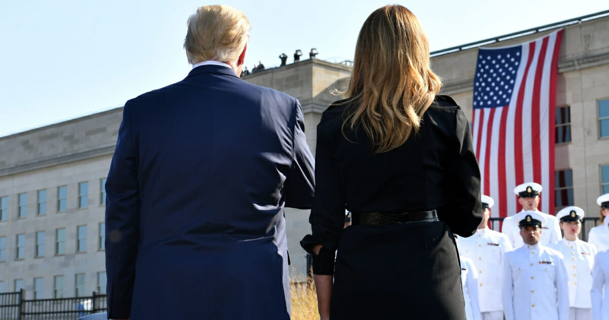President Donald Trump and first lady Melania Trump face the U.S. flag during a ceremony Sept. 11, 2019, at the Pentagon in Washington marking the 18th anniversary of the 9/11 terrorist attacks.