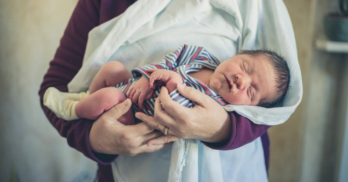 Woman holding a newborn baby.