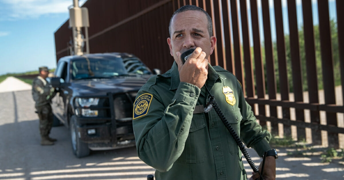 Border Patrol agent Carlos Ruiz spots a pair of undocumented immigrants while coordinating with active duty U.S. Army soldiers near the U.S.-Mexico border fence on Sept. 10, 2019, in Penitas, Texas.