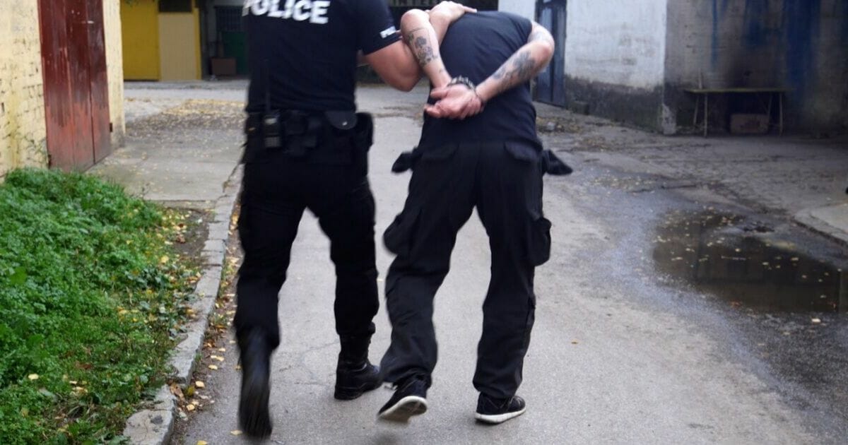 Stock image of a police officer arresting a suspect.