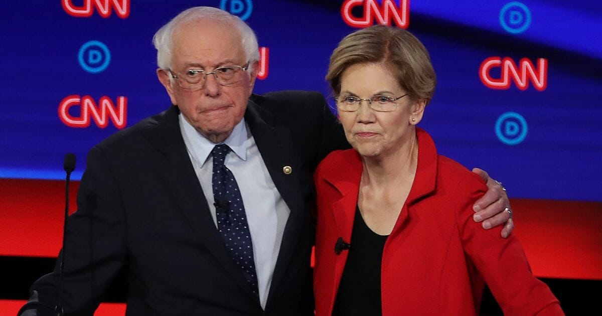 Sens. Bernie Sanders and Elizabeth Warren get close after the July 30 Democratic debate in Detroit.