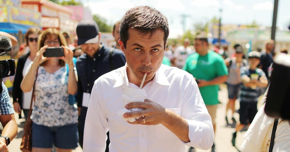 Democratic presidential candidate and South Bend, Indiana, Mayor Pete Buttigieg drinks a root beer float while talking with journalists as he walks through the Iowa State Fair on Aug. 13, 2019 in Des Moines, Iowa.