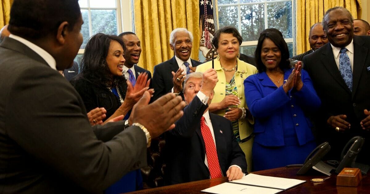 President Donald Trump hands out pens after signing an executive order supporting black colleges and universities in the Oval Office of the White House on Feb. 28, 2017, in Washington, D.C.