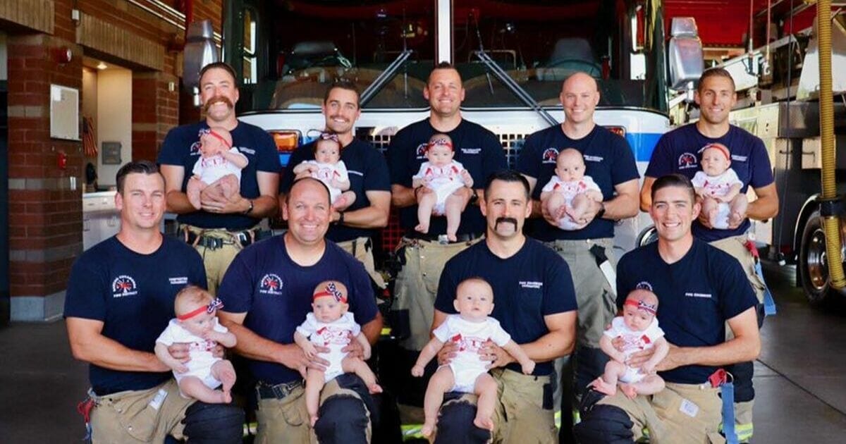 Members of the Rancho Cucamonga Fire District pose with their babies in front of a firetruck.