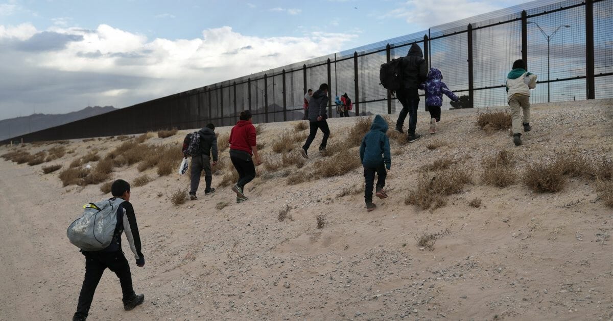 Central American immigrants approach the U.S.-Mexico border fence after crossing the Rio Grande from Mexico on Feb. 1, 2019, in El Paso, Texas.