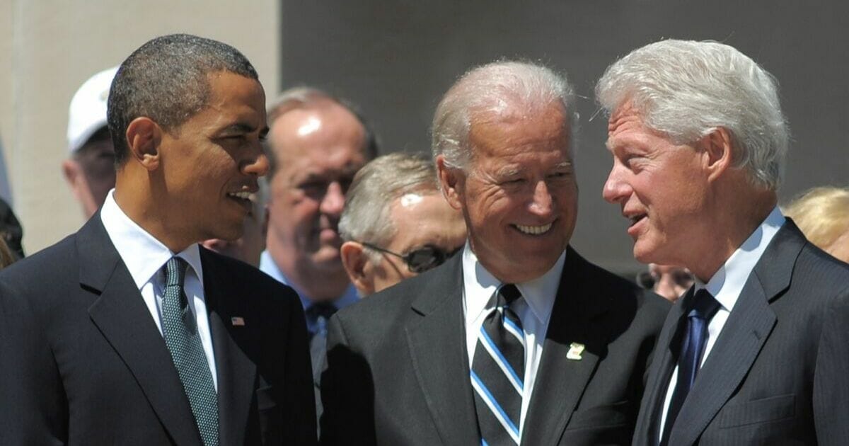 Then-President Barack Obama, then-Vice President Joe Biden and former President Bill Clinton chat before the start of a memorial service for Senator Robert Byrd on July 2, 2010, at the West Virginia State Capitol in Charleston, West Virginia.