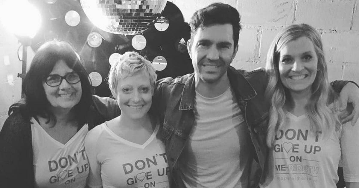 Andy Grammer stands with three women