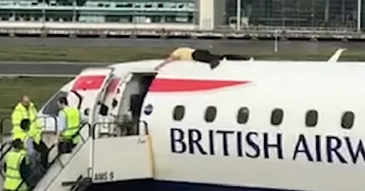 A climate change protester is prone on top of a British Airways jet at London's City Airport on Thursday.