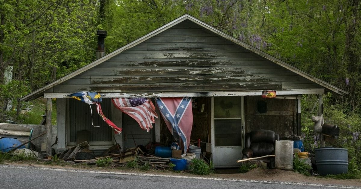 A house displays the United States, Confederate, and North Carolina flags.