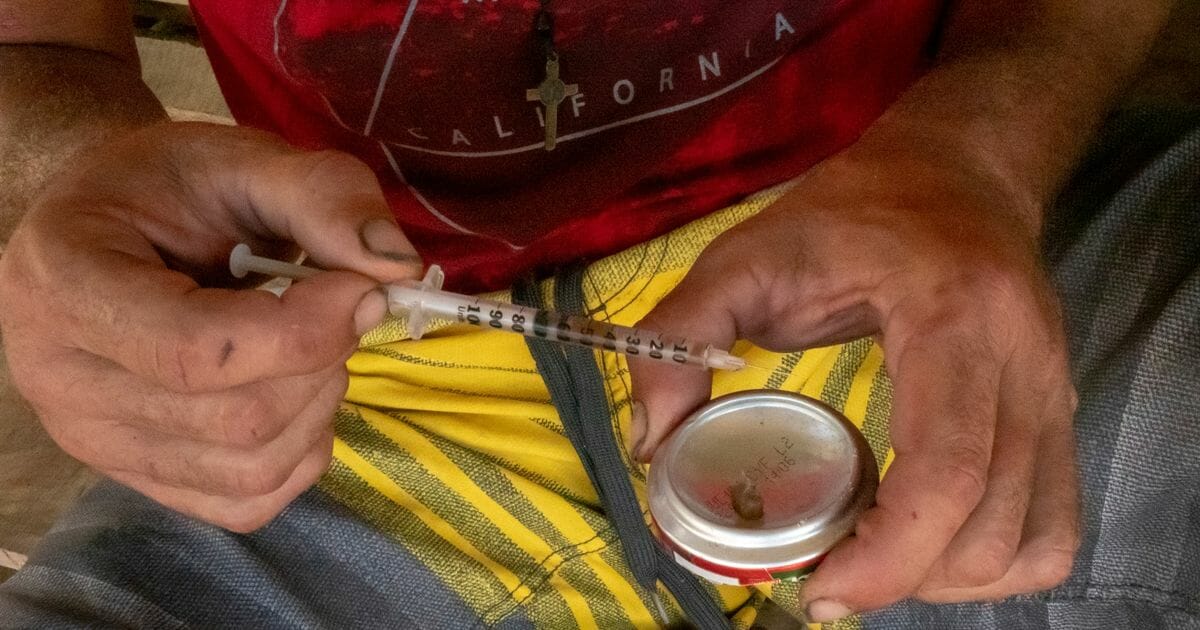 A man prepares to inject heroin in Puerto Rico.