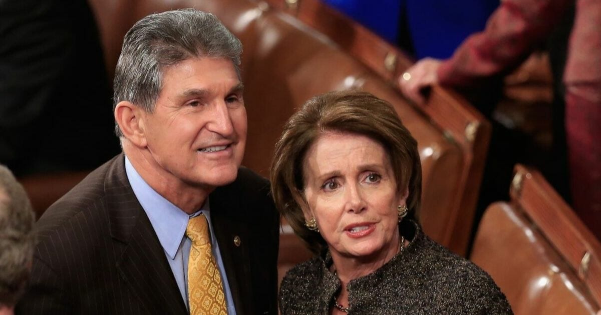 Rep. Nancy Pelosi of California talks with fellow Democrat Sen. Joe Manchin of West Virginia before the State of the Union address in the House chamber on Jan. 20, 2015.