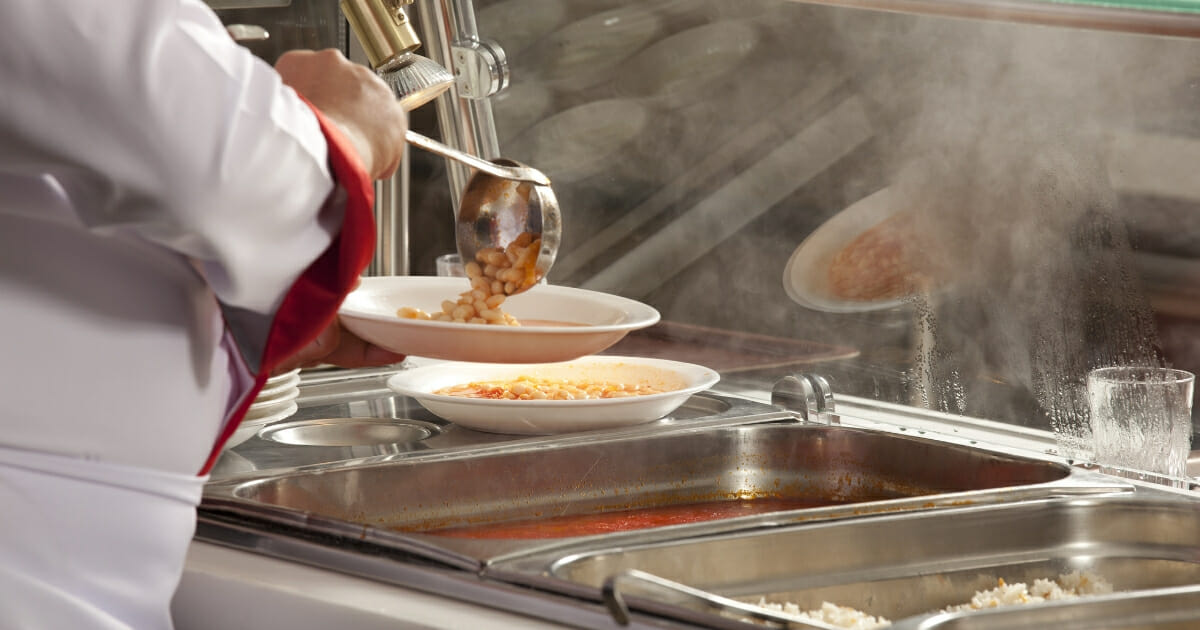 A cafeteria worker serves lunch.