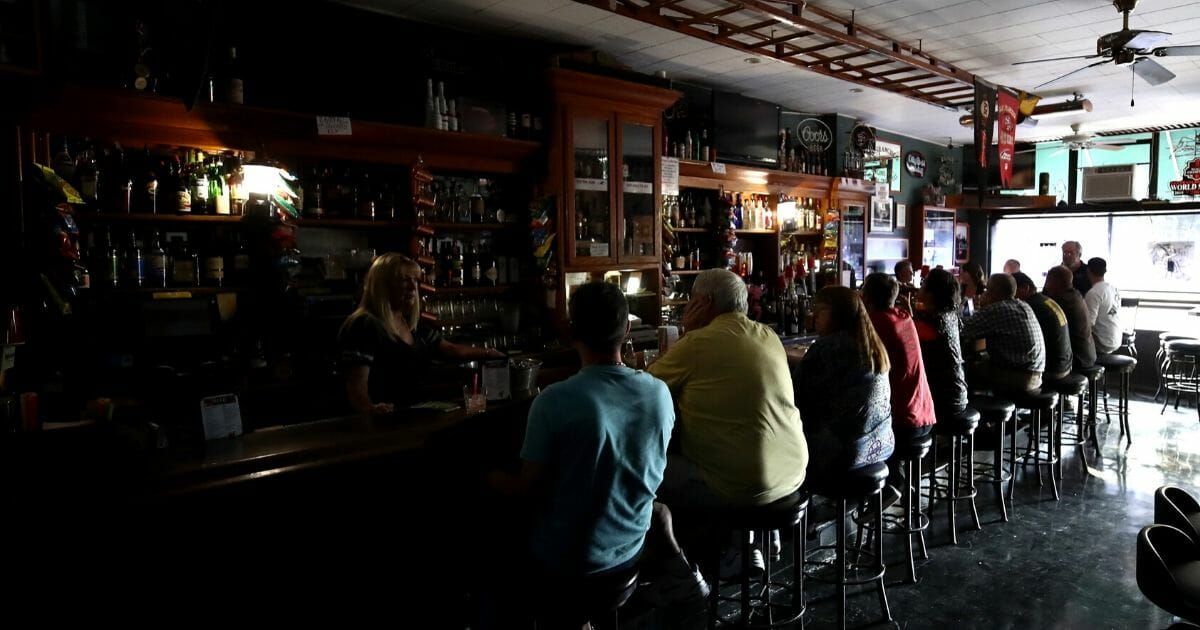 Cathy Sanchez bartends at The Town Square bar, where the lights were out on Oct. 10, 2019, in Sonoma, California. Power outages were scheduled as preemptive moves by PG&E to address hot, dry and windy weather and the risk of wildfires, according to the company.