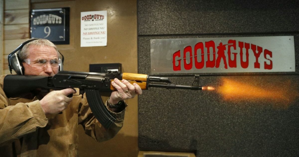 A man fires an AK-47 outfitted with a bump stock.