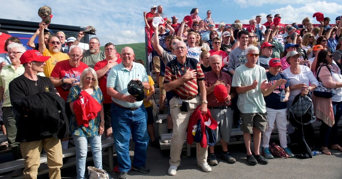 Supporters stand for the Pledge of Allegiance before U.S. President Donald J. Trump held a "MAGA" rally at the Williamsport Regional Airport.