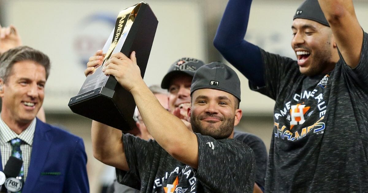 Jose Altuve of the Houston Astros holds the trophy for American League Championship Series Saturday night at Minute Maid Park in Houston.