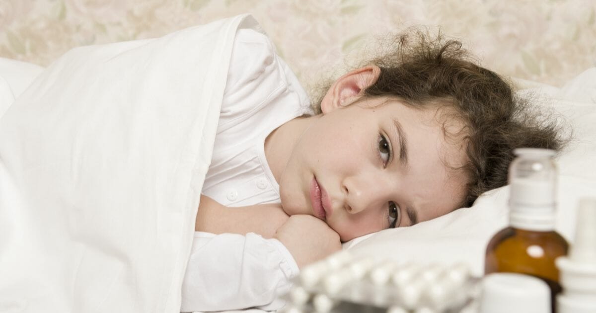 Stock image of a sick child in bed.