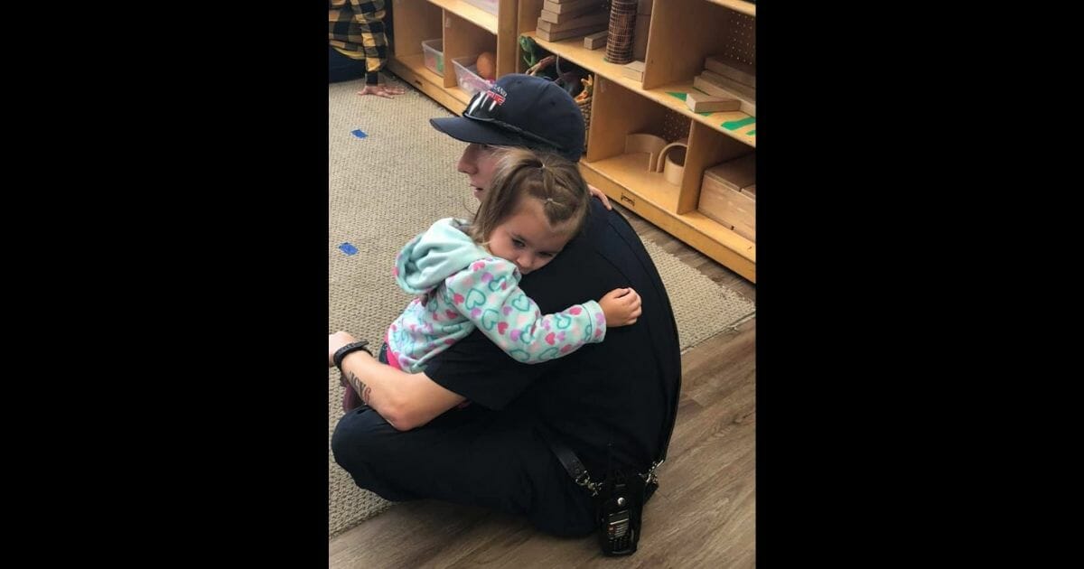 Officer Anthony Banas of the Wheatland Fire Authority in Wheatland, California, comforts a young girl who has autism.