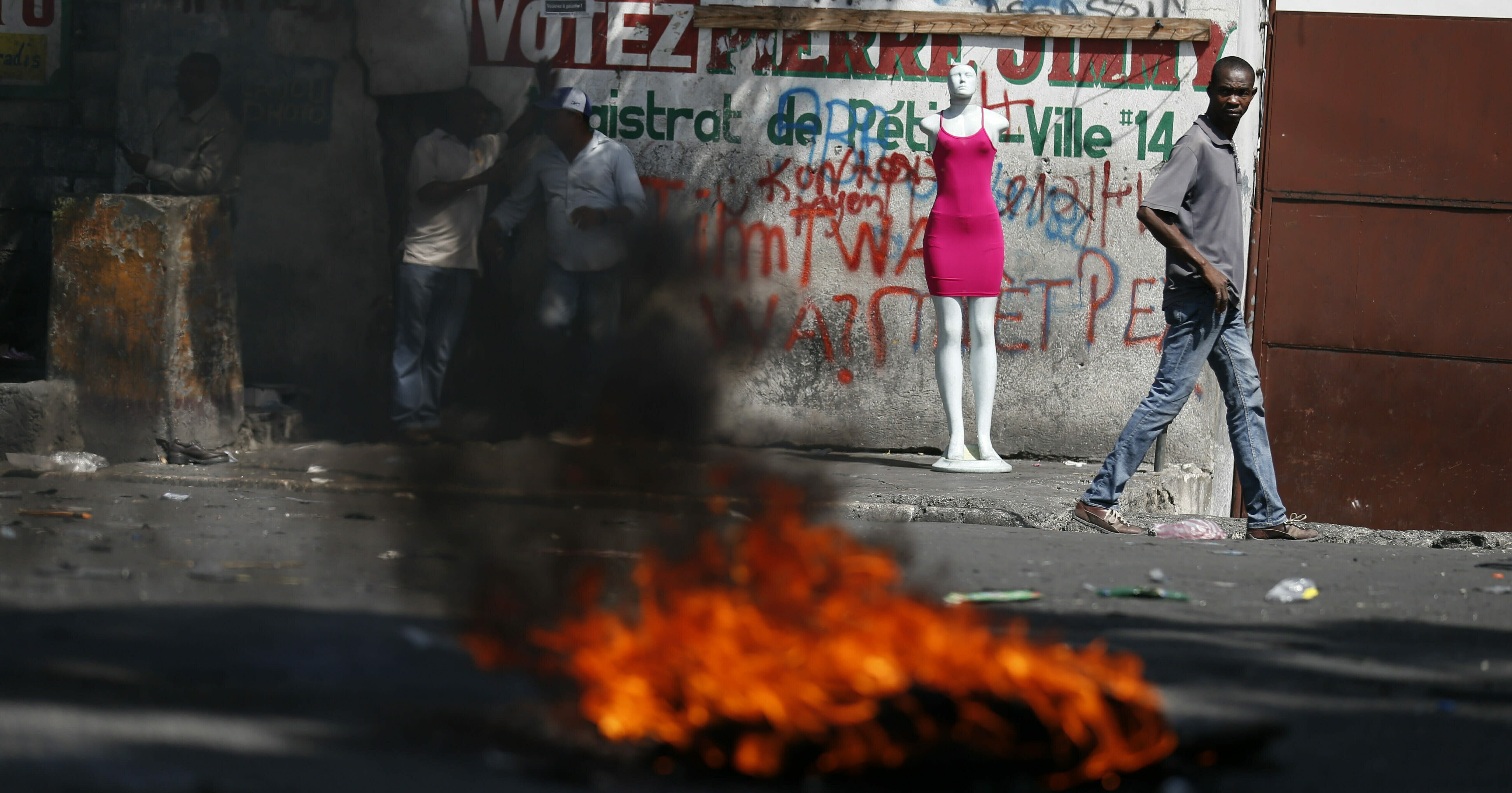 A man walks past a burning barricade during anti-government protests in Port-au-Prince, Haiti, on, Oct. 11, 2019.