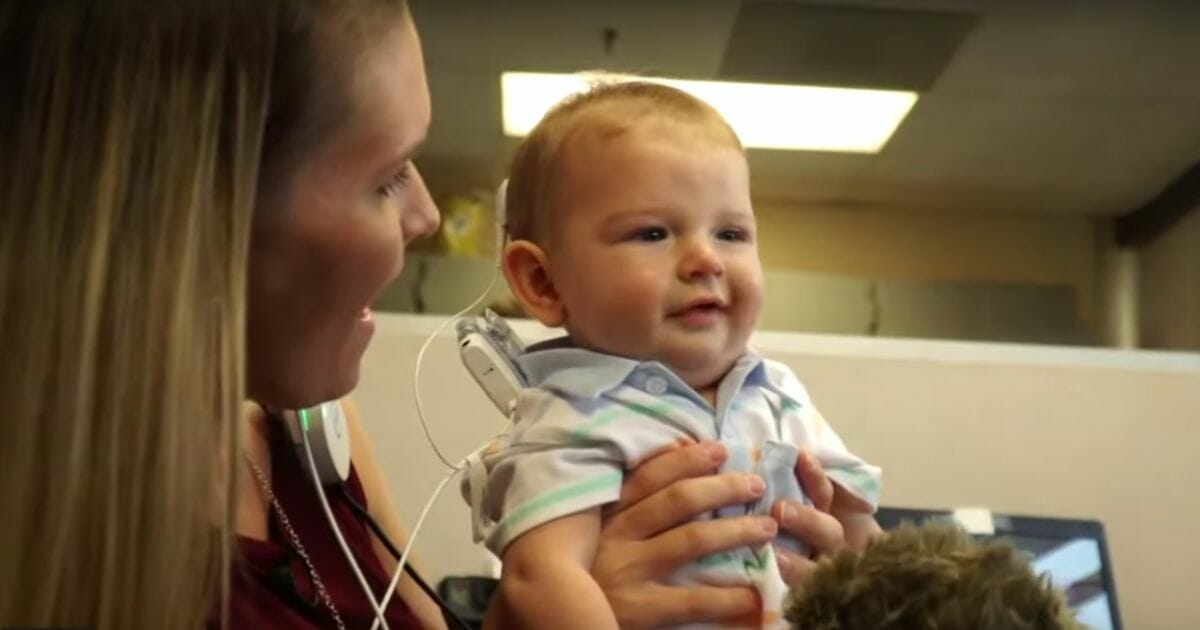 Baby hears for first time with hearing implants.