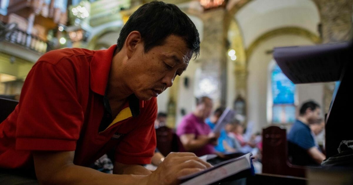 A man reads a bible during a mass at the South Cathedral in Beijing.