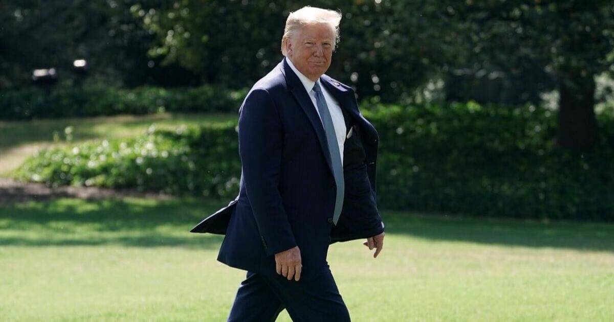 President Donald Trump walks across the South Lawn.